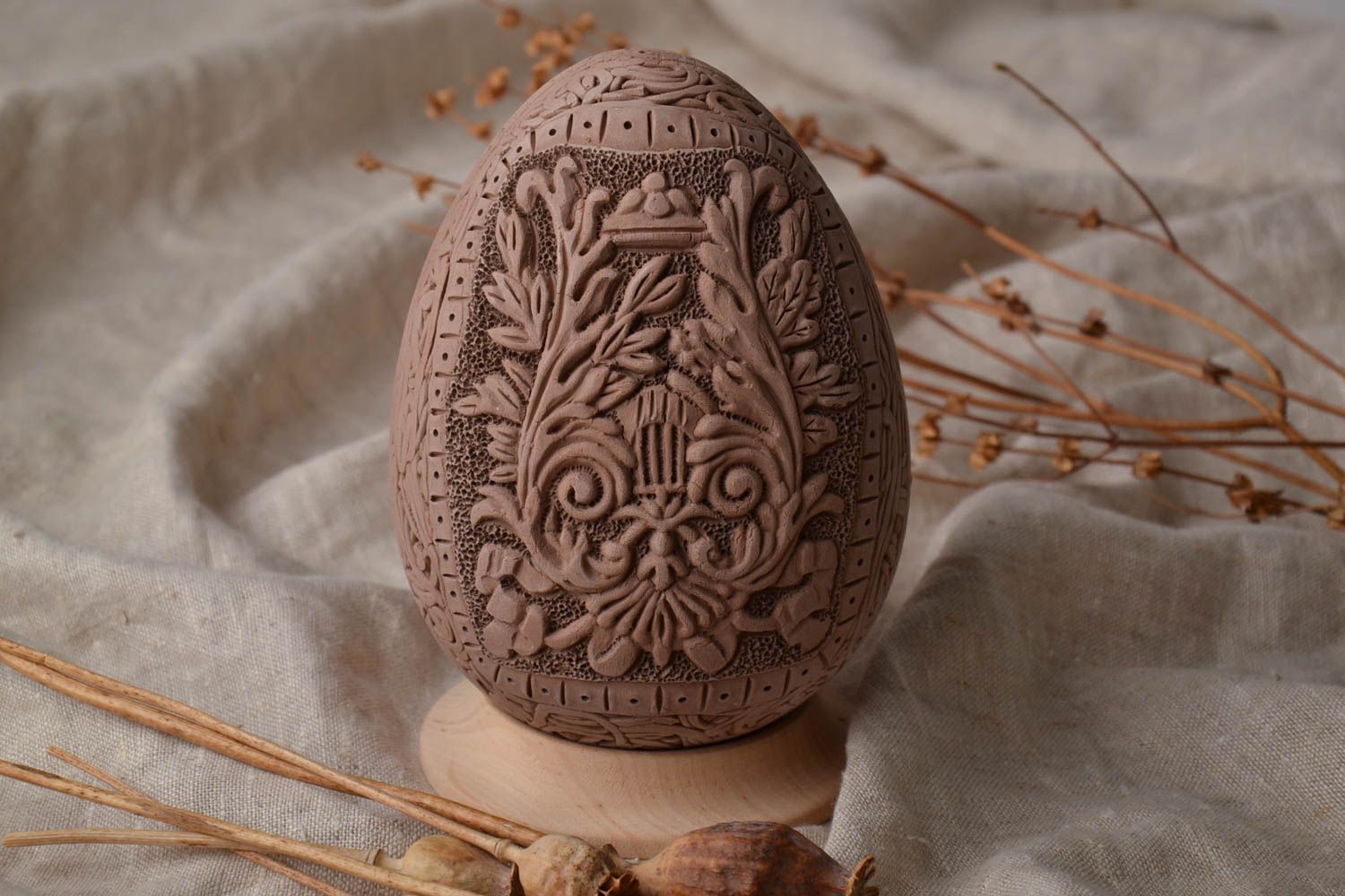Ceramic Easter egg with elegant molded elements and wooden holder photo 1