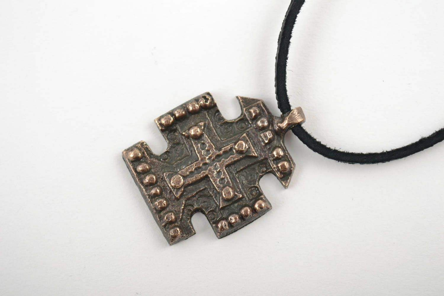 Pequeña cruz de bronce para el cuello hecha a mano en cordón foto 3