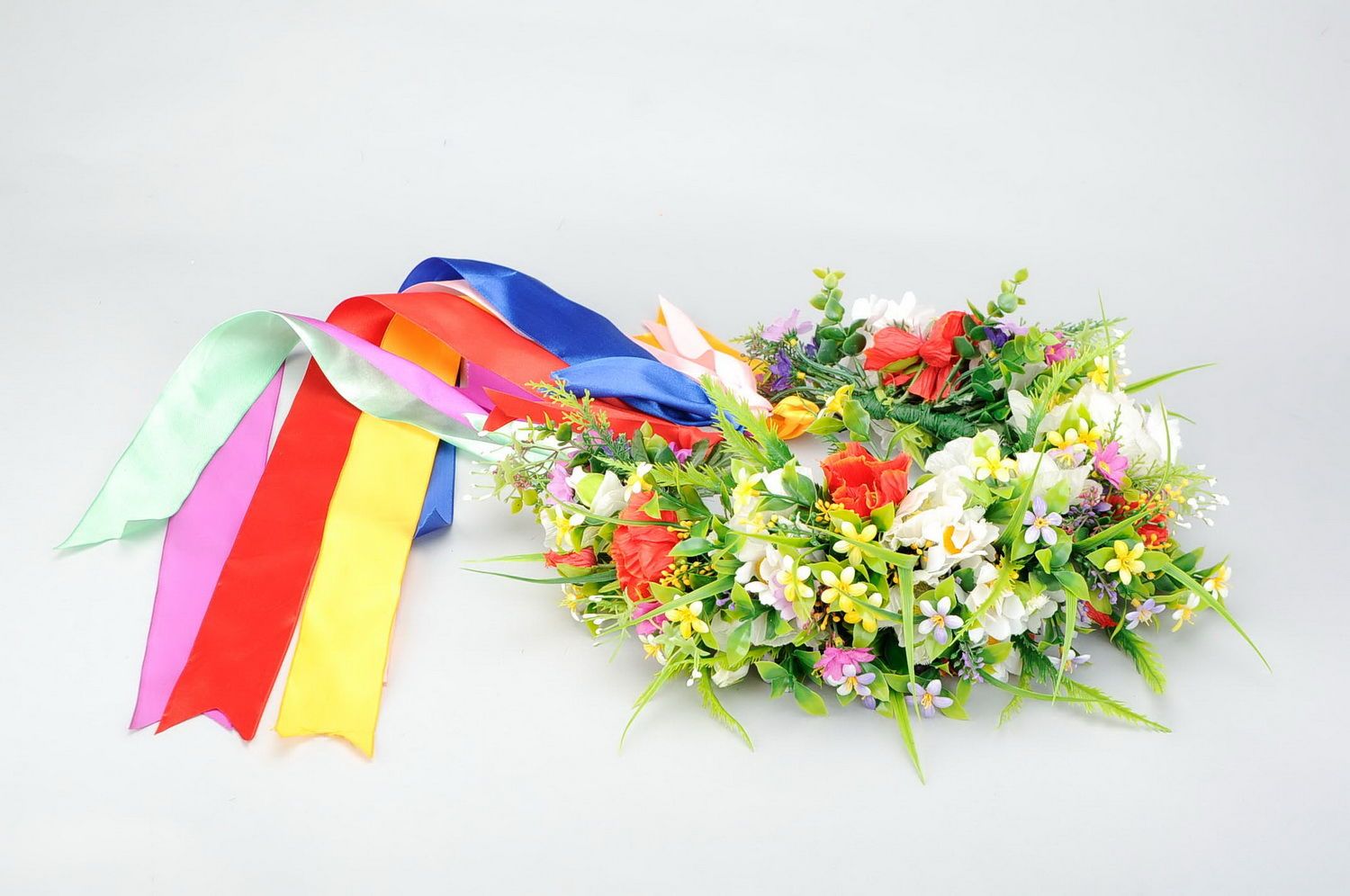Wreath with artificial flowers and satin ribbons photo 1