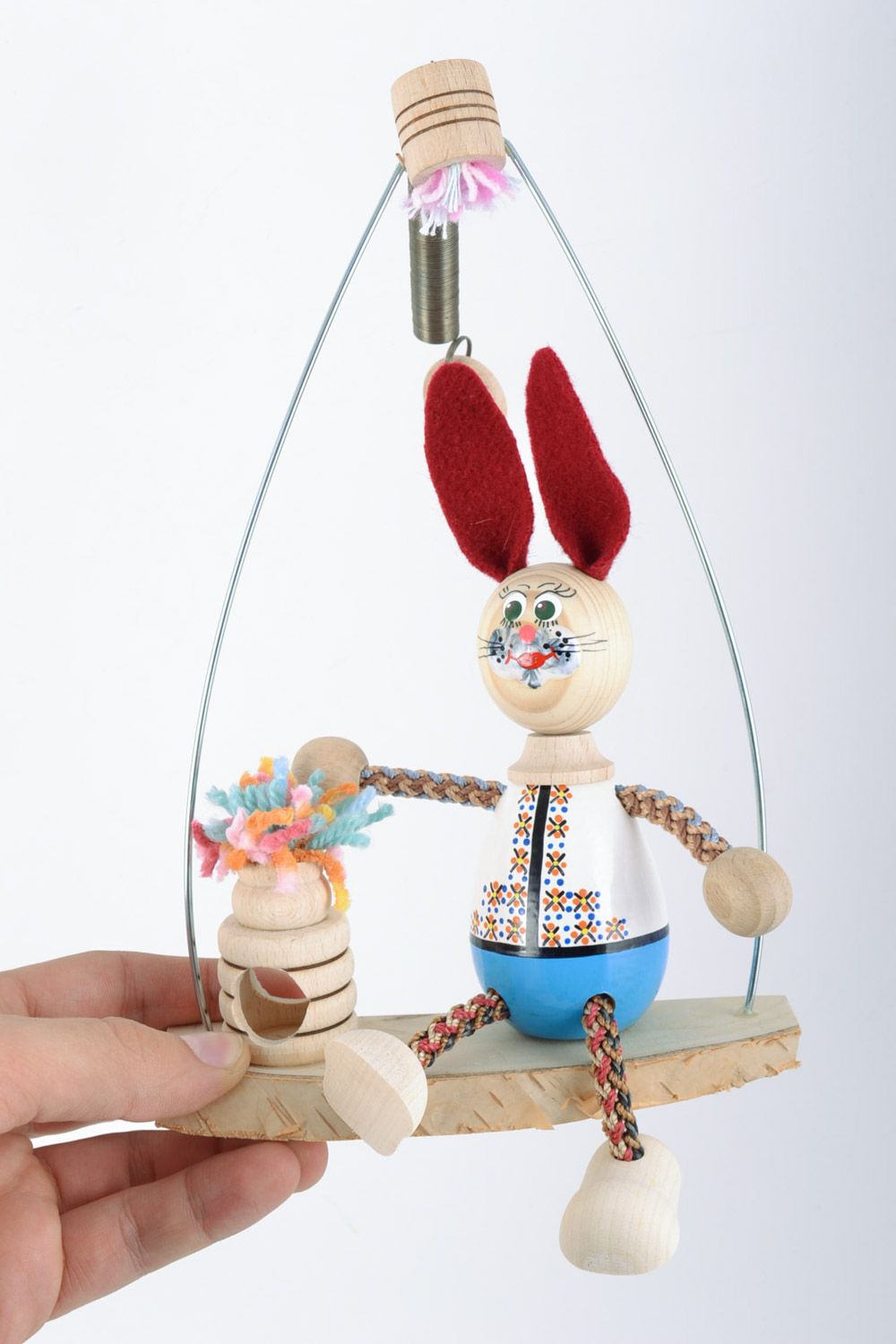 Handmade cute painted beech wood eco toy rabbit with red ears sitting on swing  photo 2