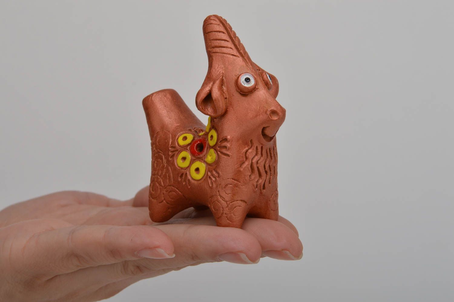 Глиняная свистулька в виде козлика с цветком на боку игрушка ручной работы фото 3