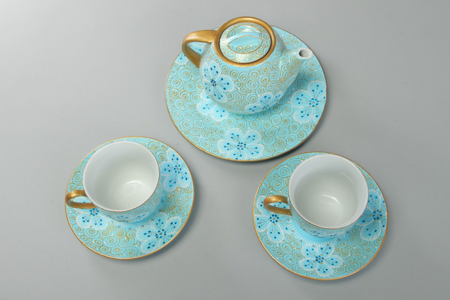 Hand-painted ceramic tea set in blue and gold colors teapot and two cups with handles and saucers photo 2