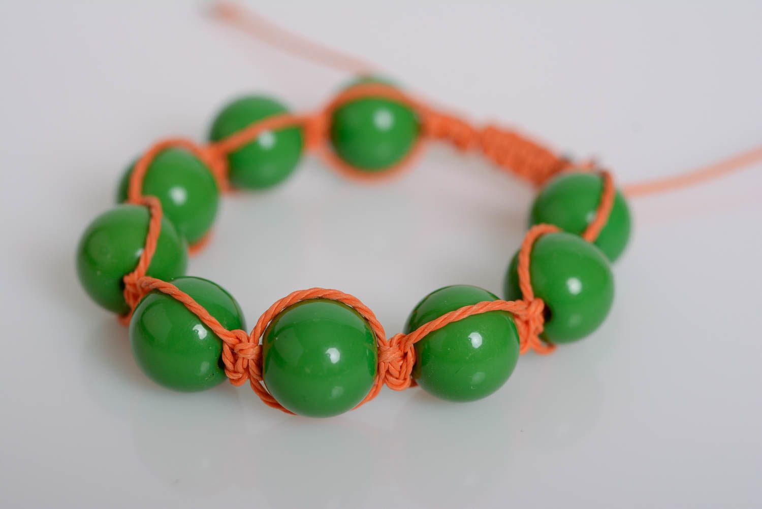 Künstlerisches Armband aus Perlen Plastik an Wachsschnur grün oranges handgemacht foto 1