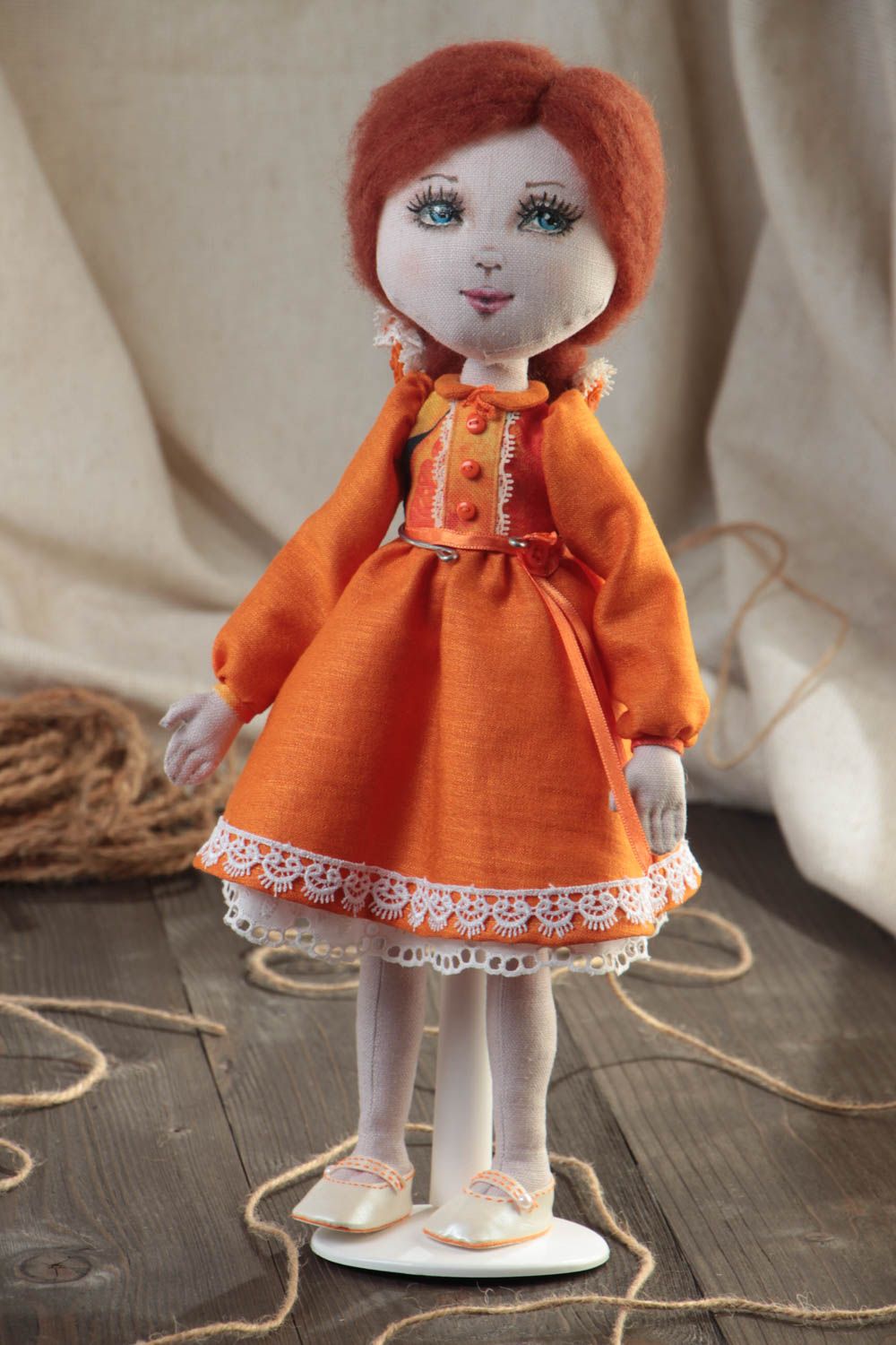 Handmade designer fabric soft doll in orange dress with thin lace on stand photo 1