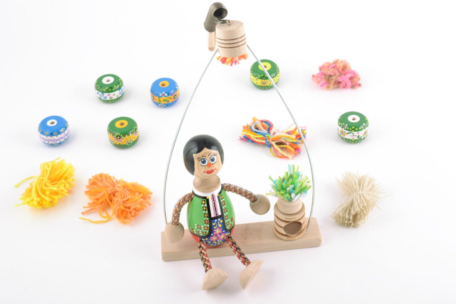 Handmade painted wooden eco toy boy in costume with flower on swing photo 1
