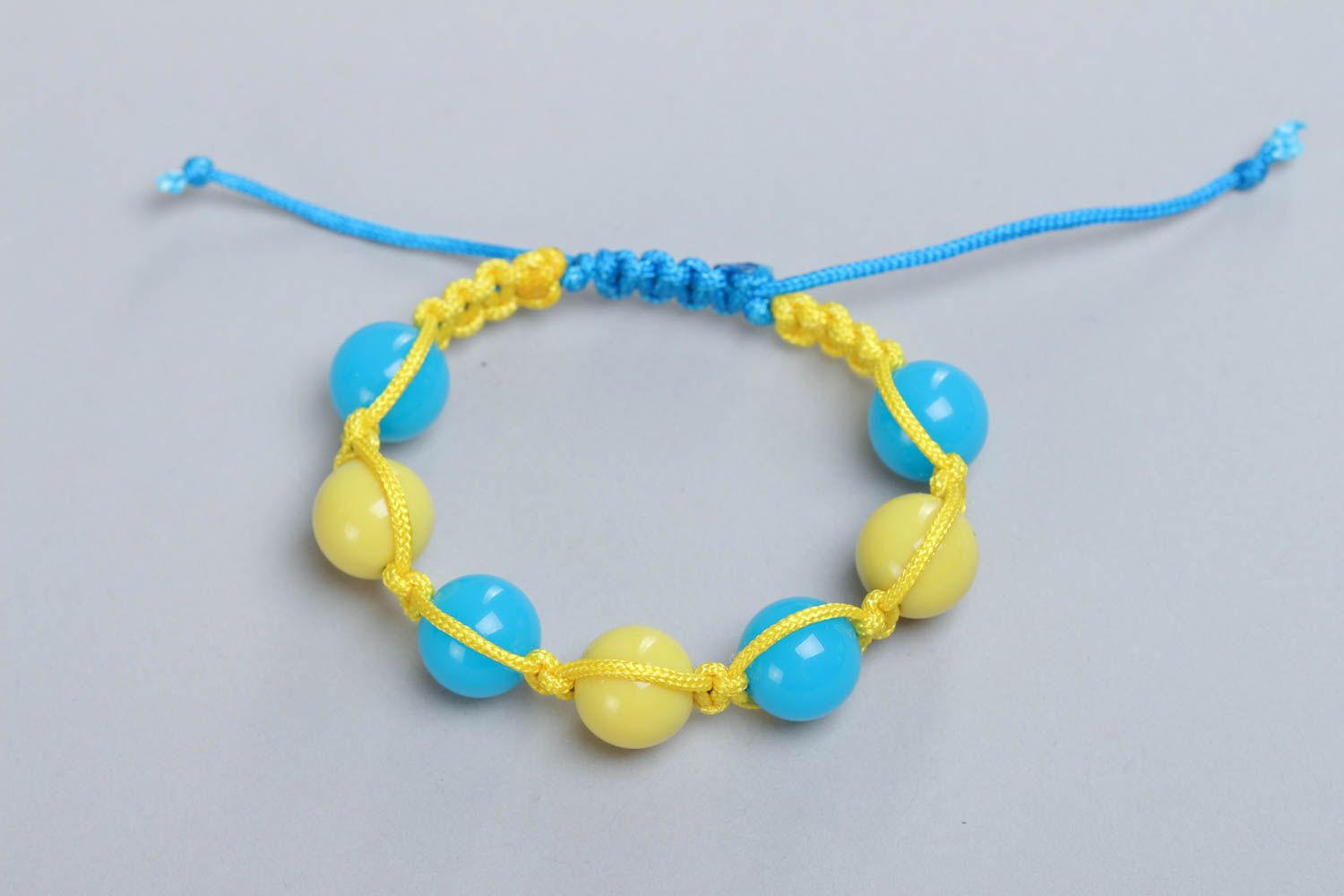 Bracelet en fils et perles plastiques tressé jaune et bleu fait main pour femme photo 2
