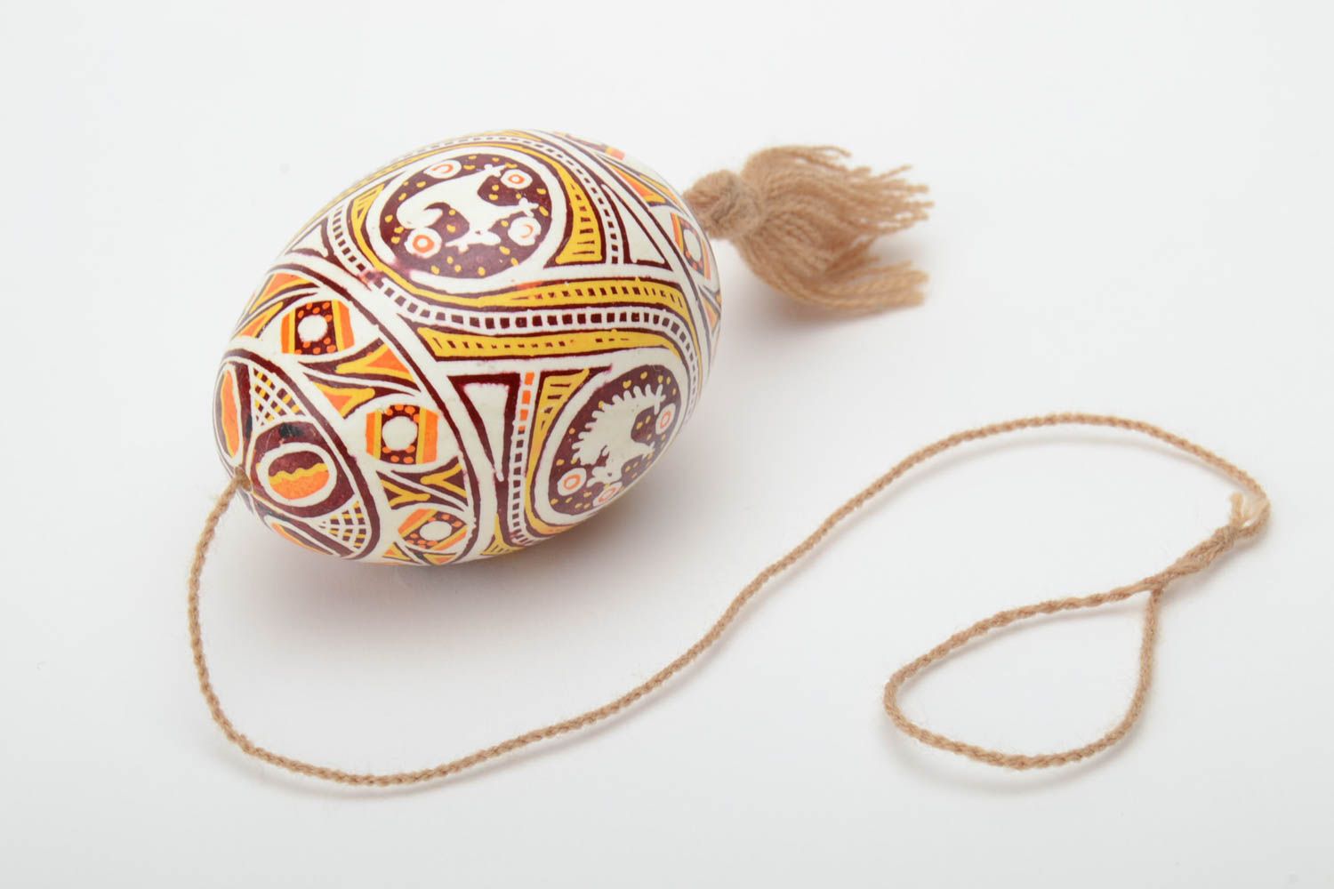 Homemade painted Easter egg with tassel and patterns created using waxing technique photo 2