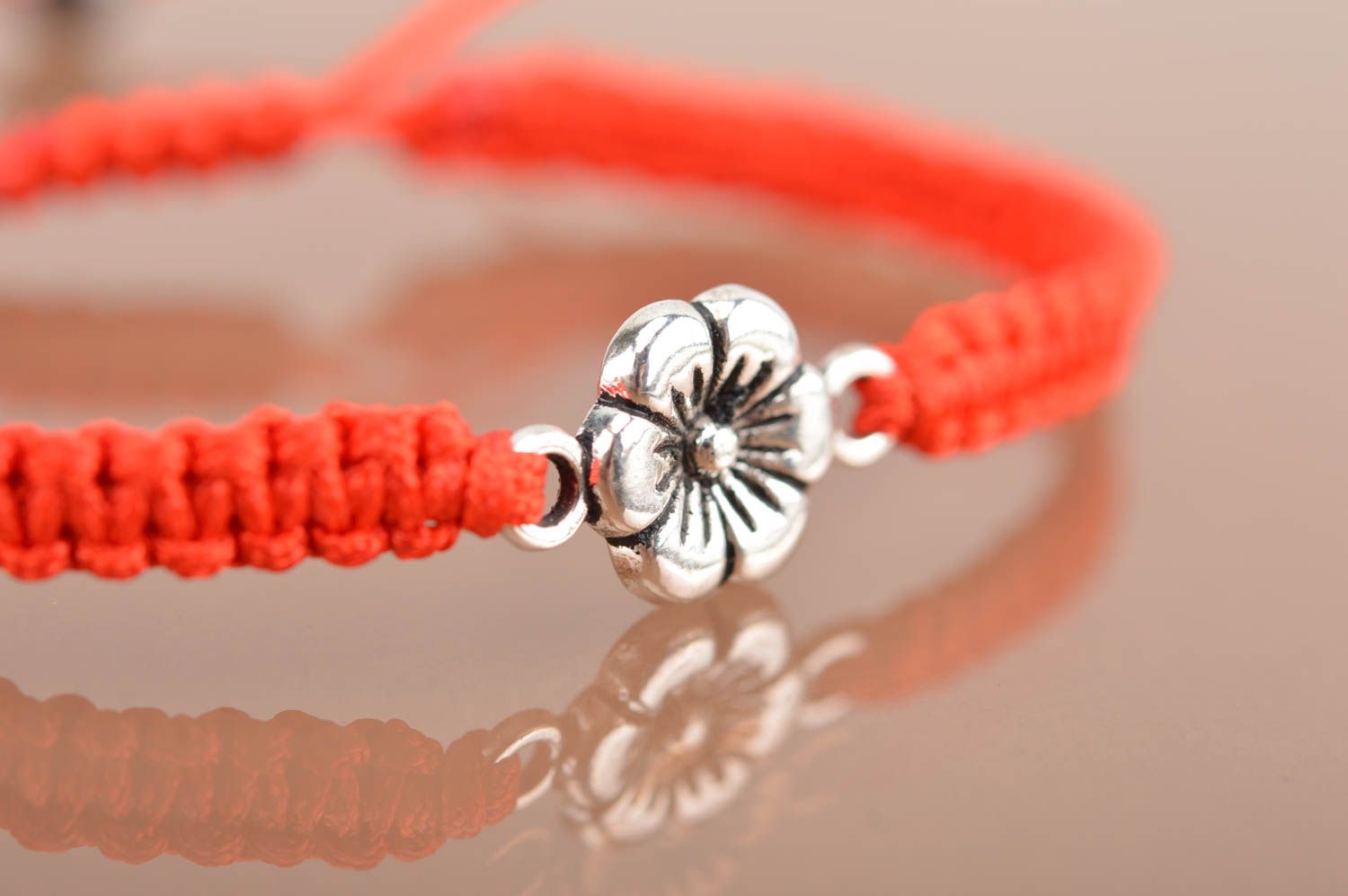 Handmade red bracelet made of silk threads with flower created of metal photo 4