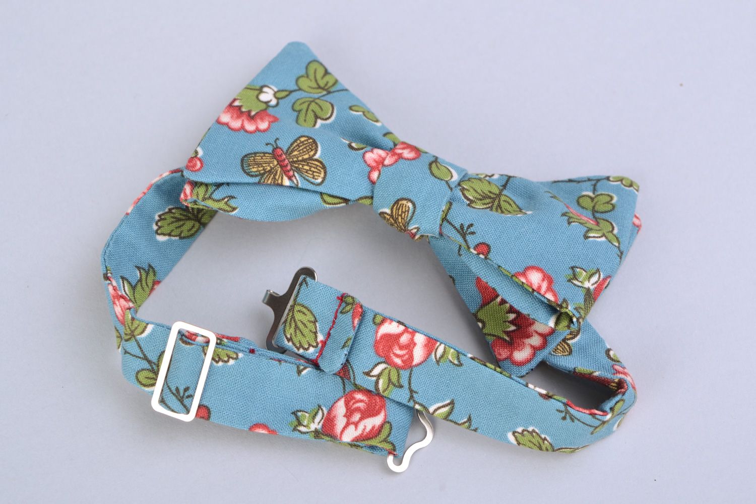 Handmade bow tie sewn of American cotton with flower pattern on blue background photo 4