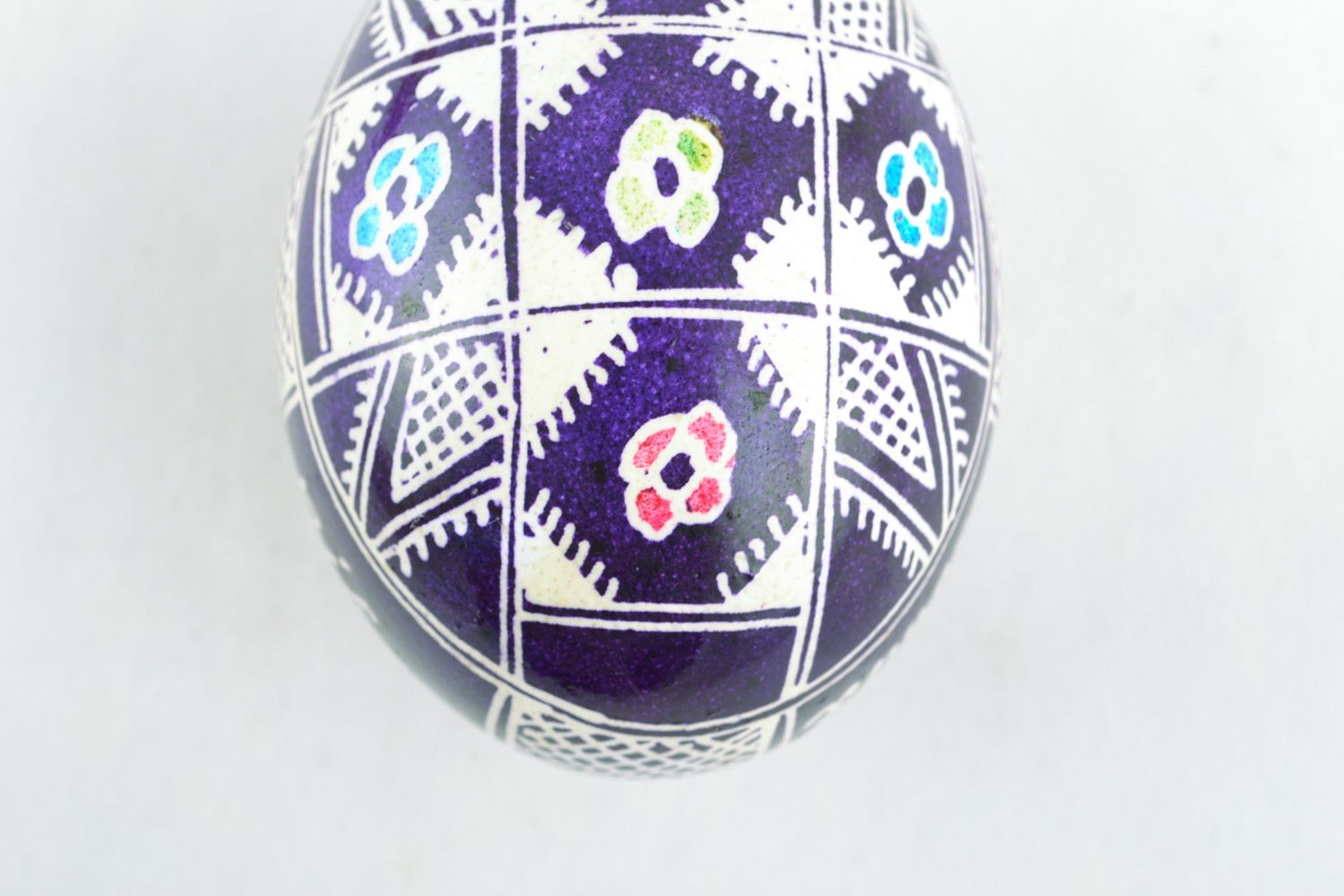 Handmade Easter egg with floral ornament painted with wax in violet color palette photo 4