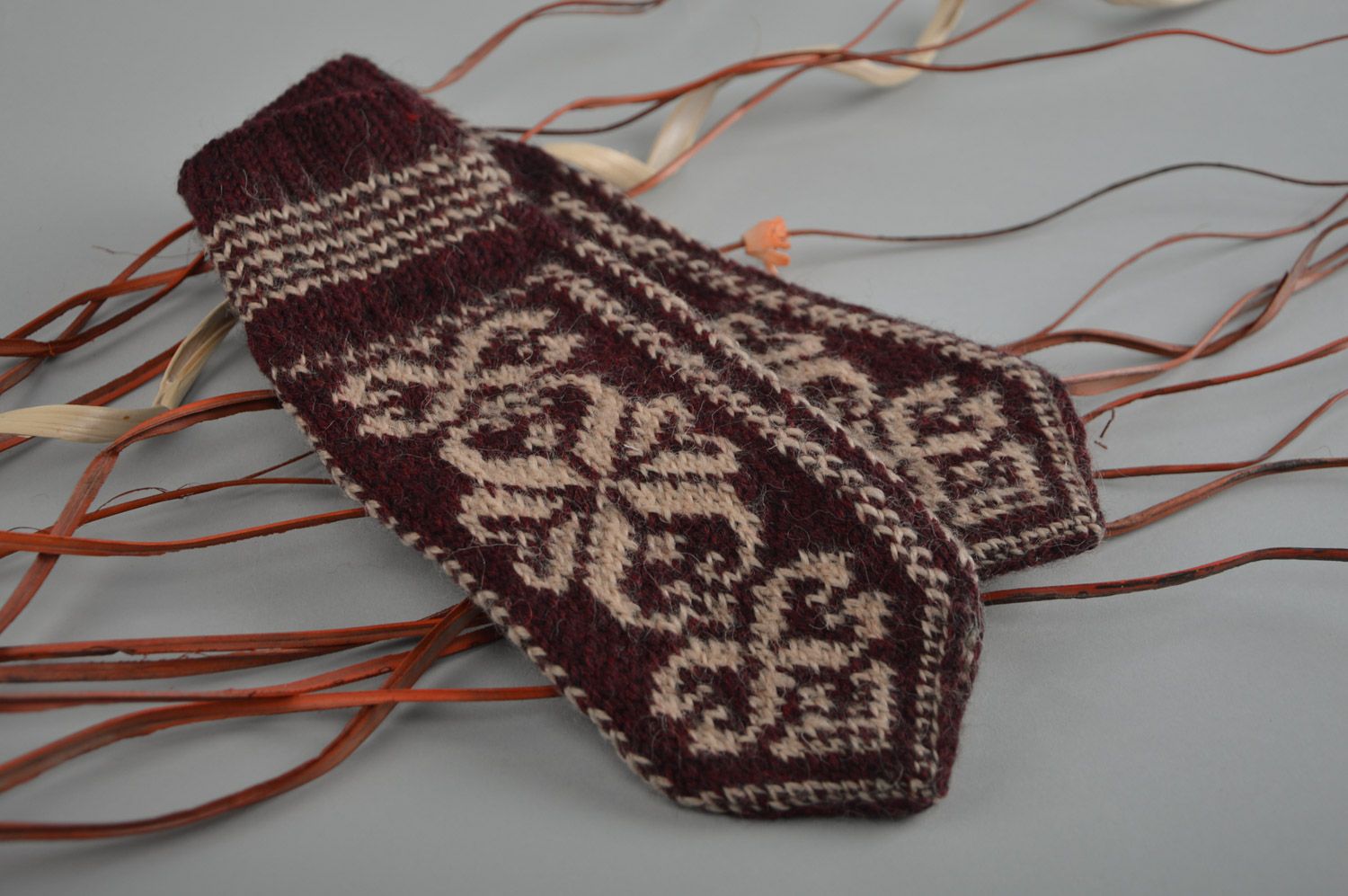 Homemade warm winter knit woolen mittens with ornaments in brown color palette photo 1