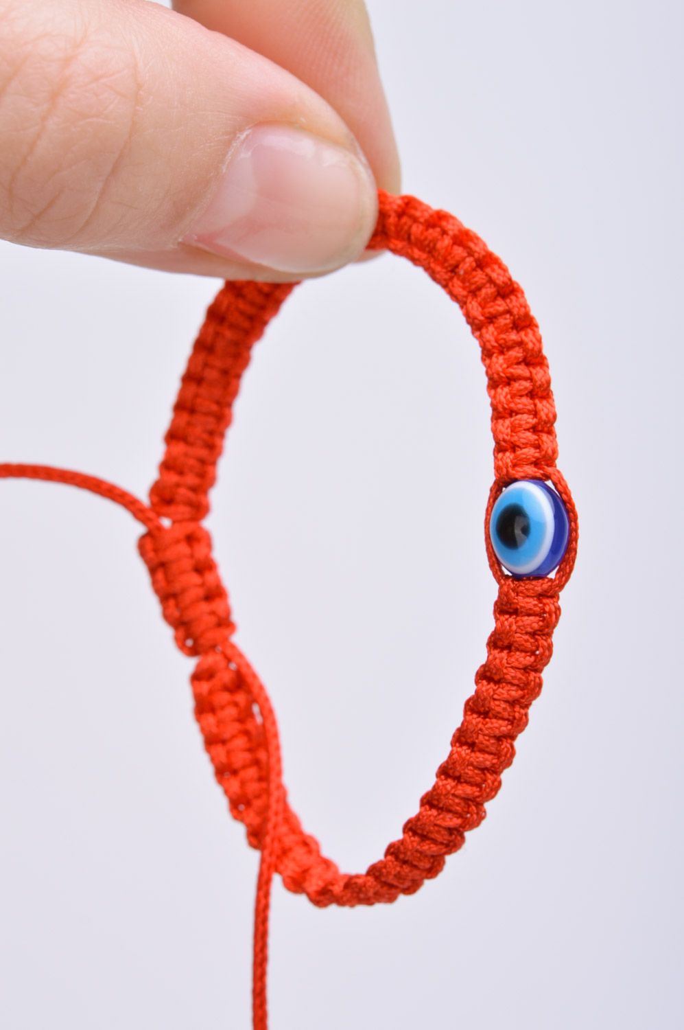 Плетеный браслет на руку из ниток красный ручной работы с бусинкой от сглаза фото 3