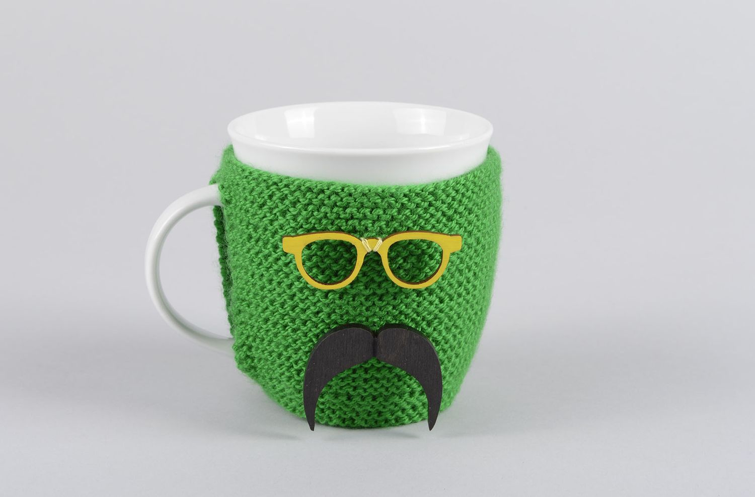 White ceramic porcelain teacup with handle and green man with mustache knitted cover photo 1