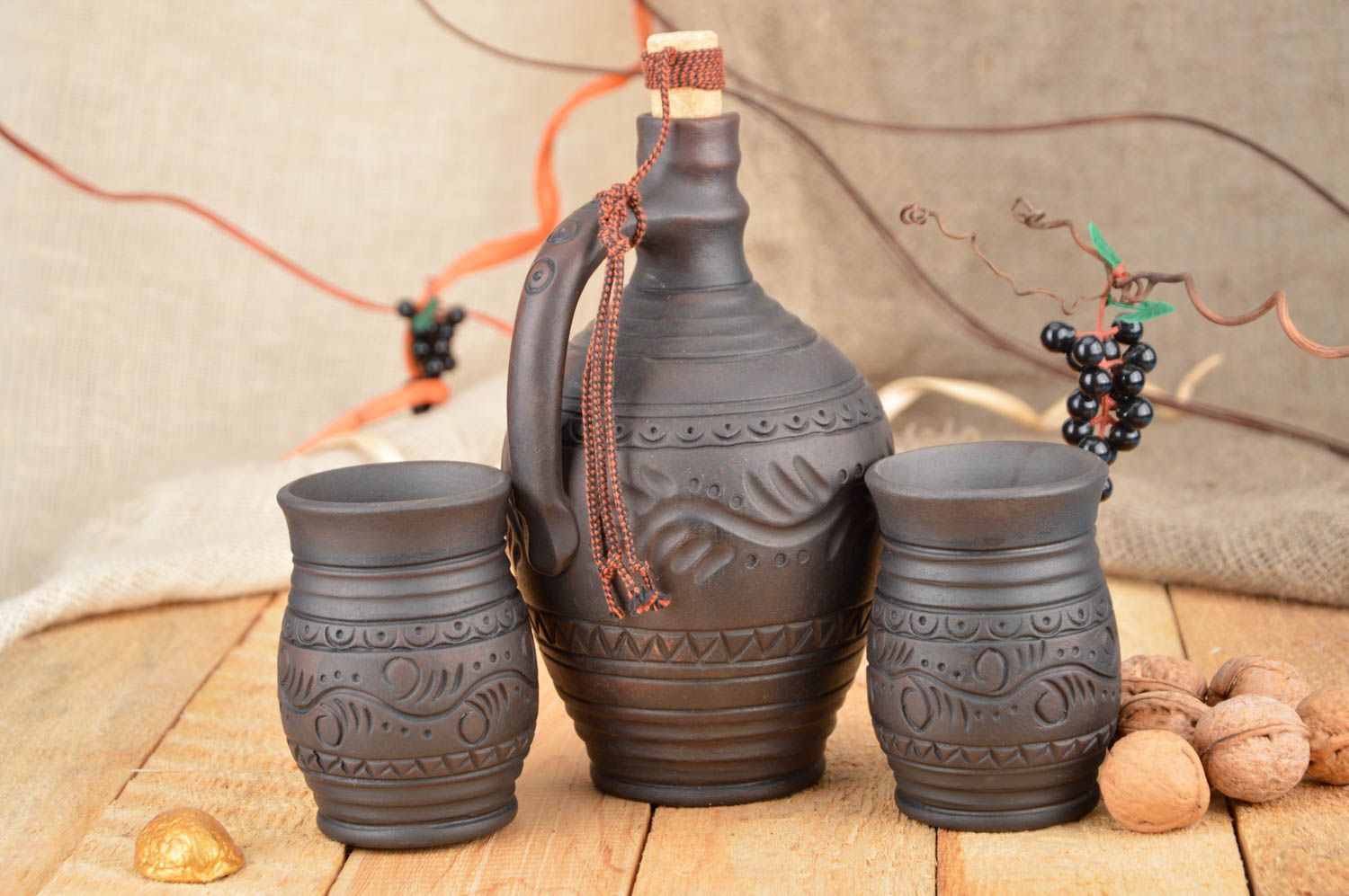 Set of dark brown ceramic drinkware pottery of wine bottle and two wine cups with rustic pattern photo 1