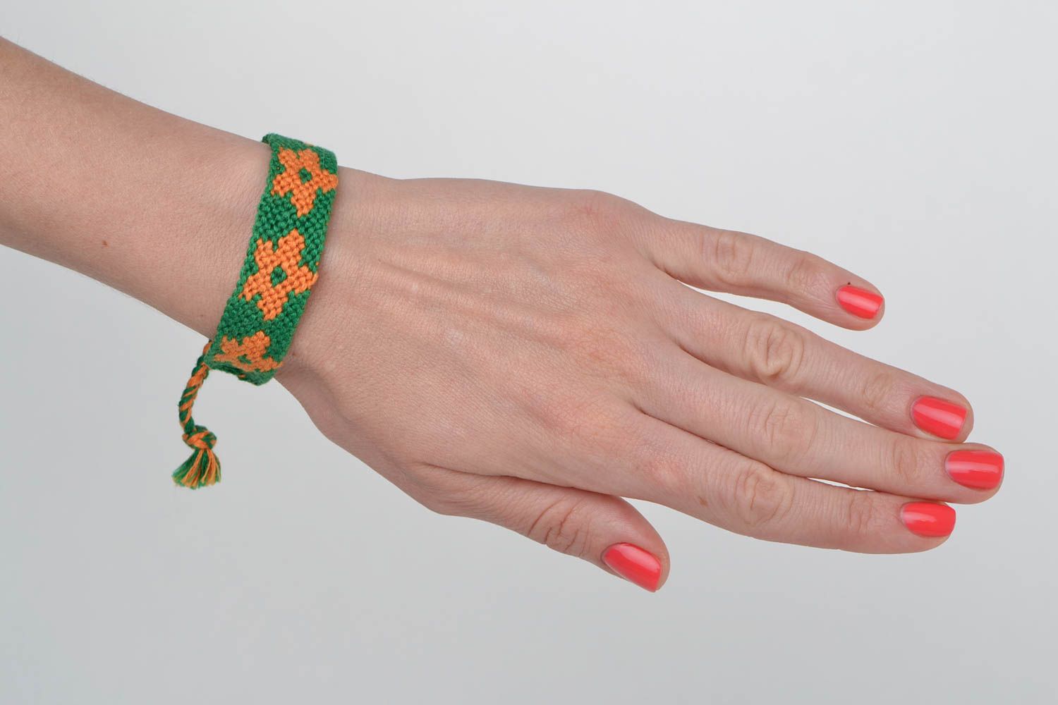 Зеленый плетеный браслет из ниток в технике макраме с оранжевыми цветами ручной работы фото 2