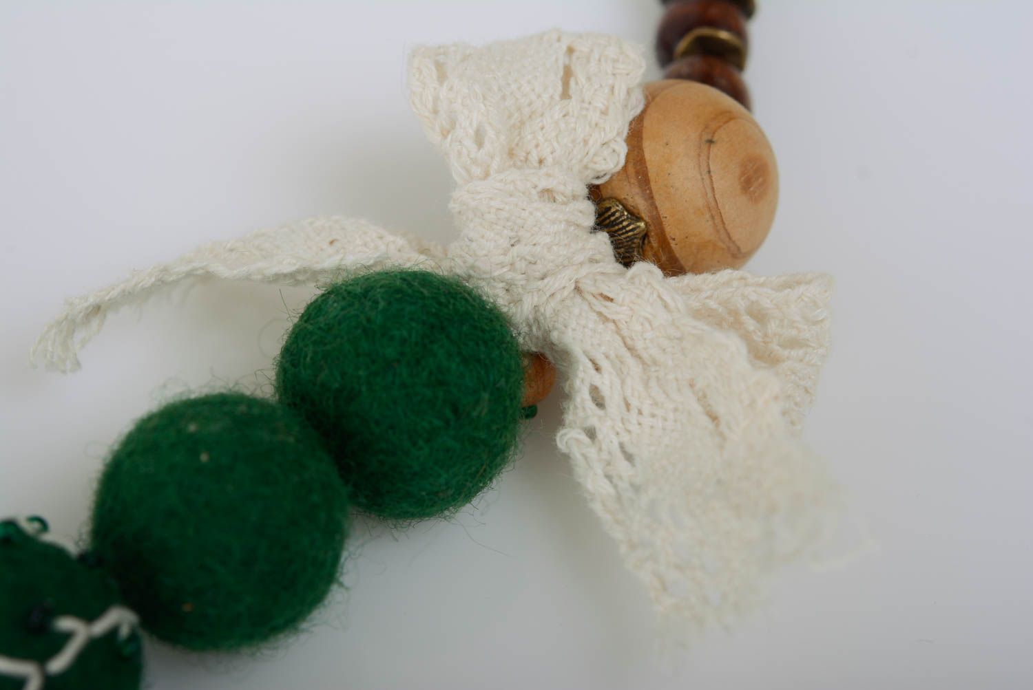 Collier en perles de laine et de bois fait main vert avec noeud sur chaîne photo 2