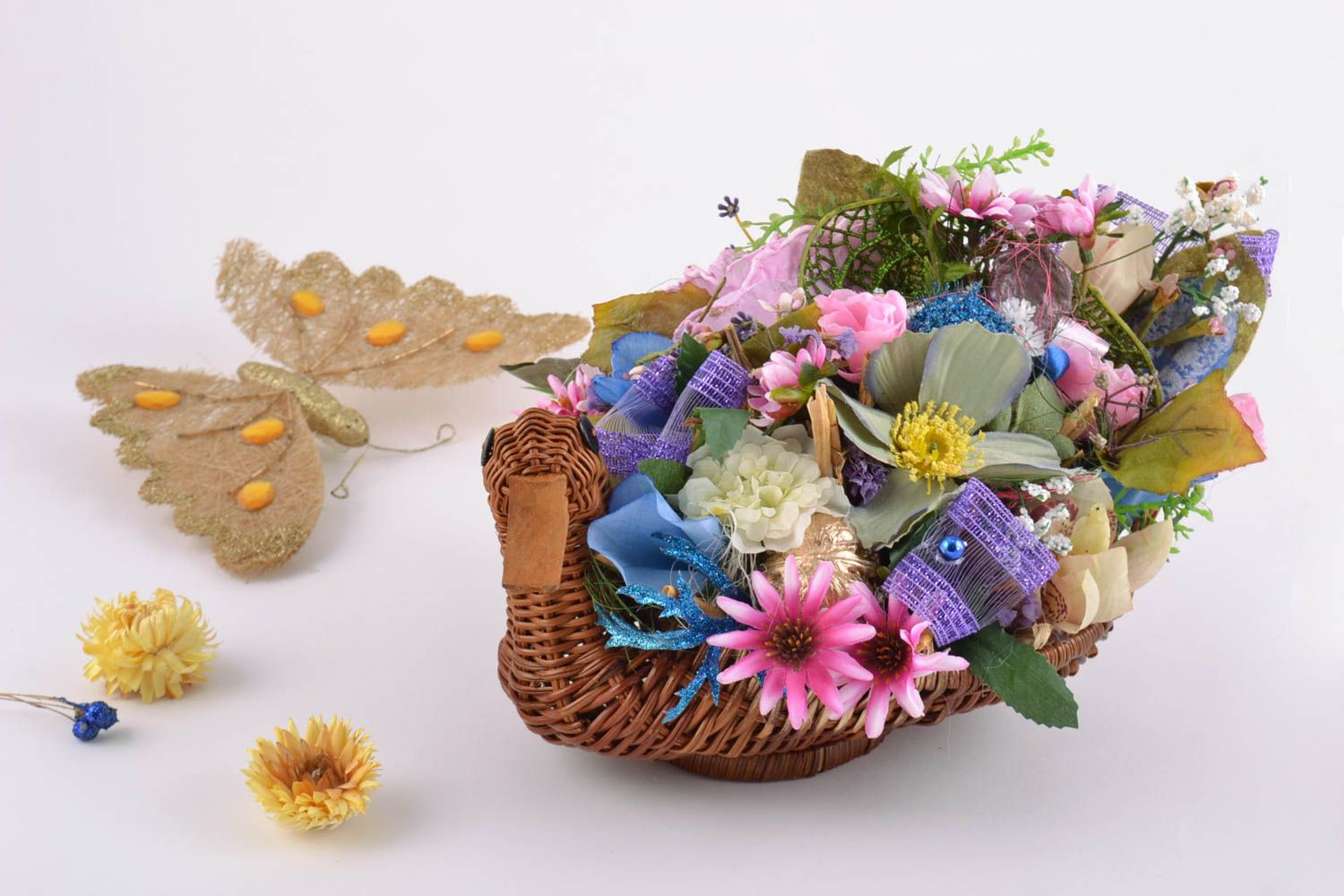 Handmade ikebana made of artificial flowers in wicker basket in the form of duck photo 1