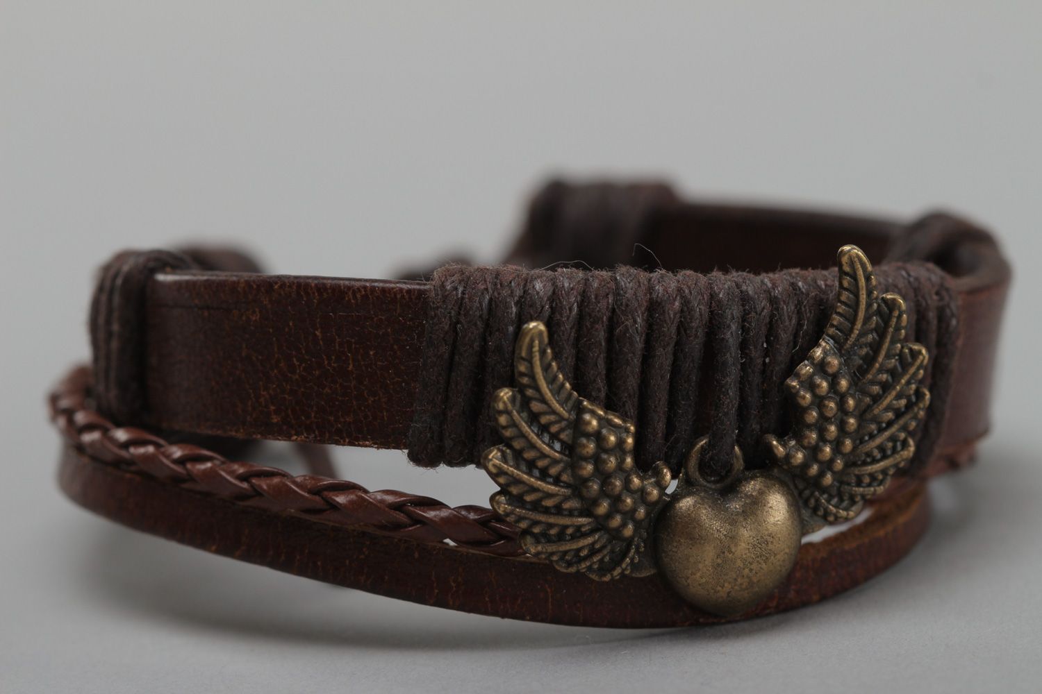 Dark brown handmade wrist bracelet woven of genuine leather with metal wings photo 3