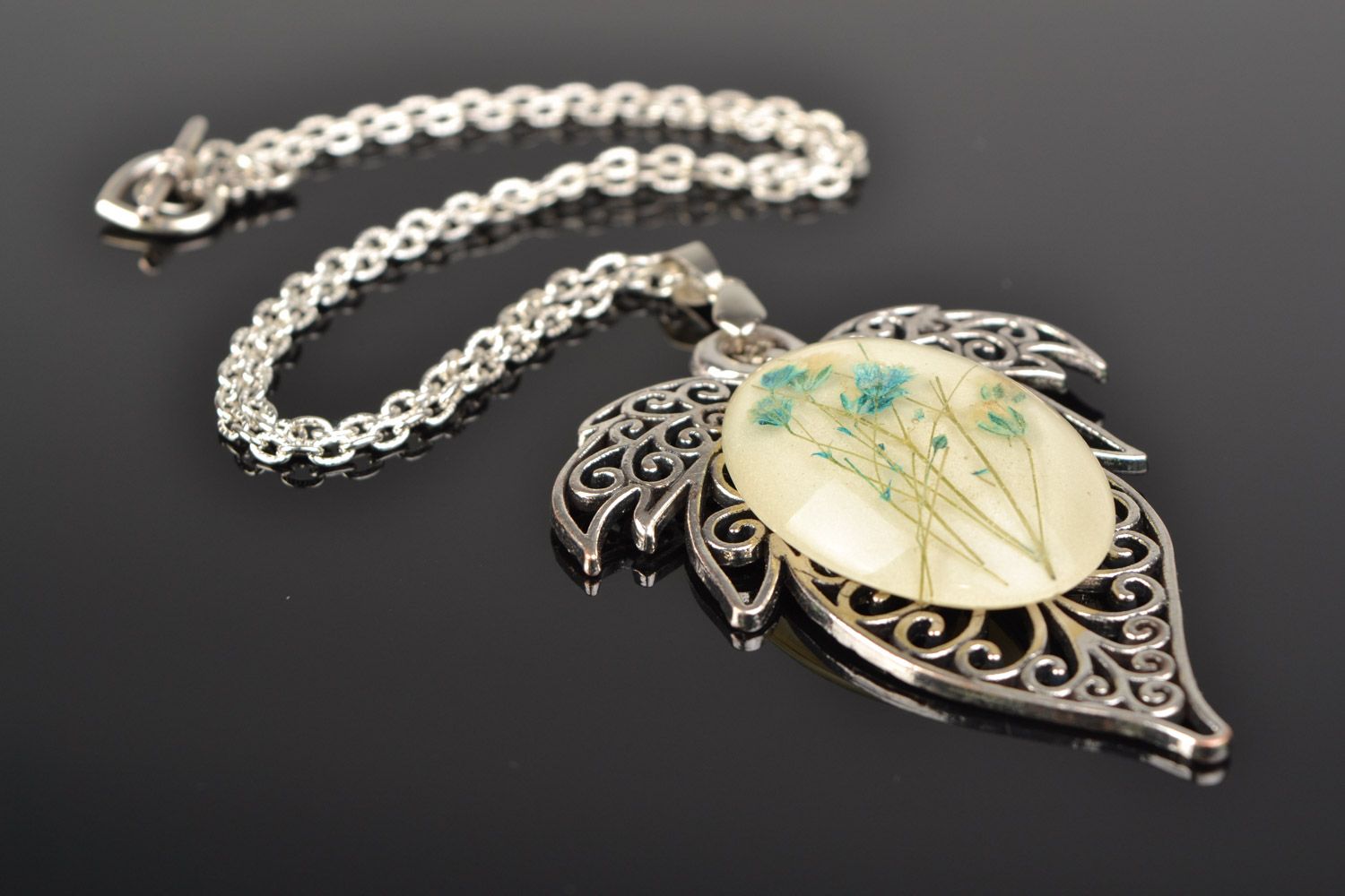 Handmade lacy leaf-shaped pendant with natural flowers in epoxy resin on chain photo 1