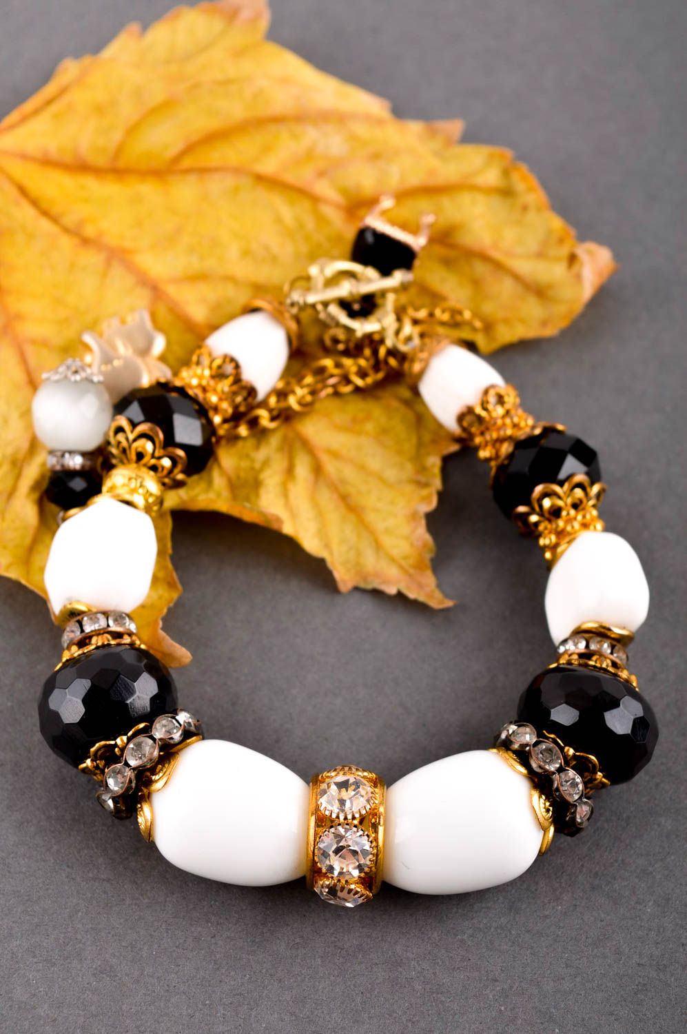 Handmade gemstone beaded bracelet with black and white beads and gold color charms for girls photo 1