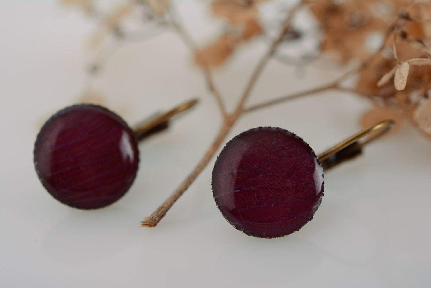 Handmade small dark round earrings with flower petals coated with epoxy resin photo 1
