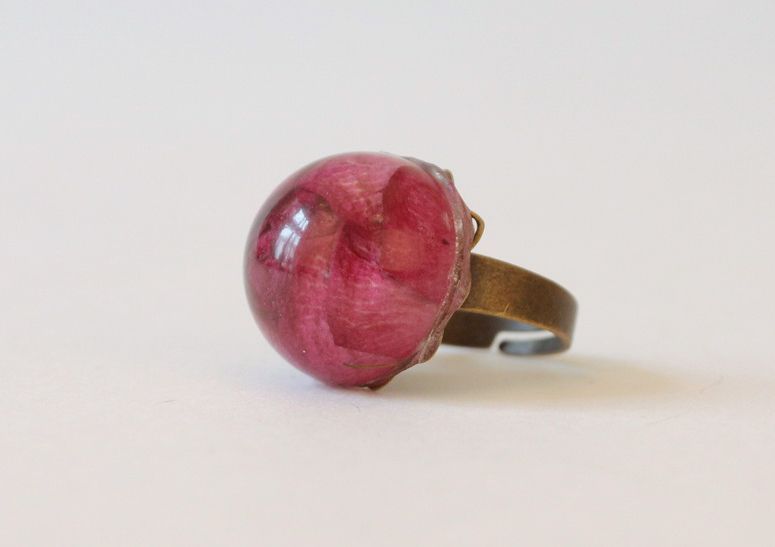 Anel de metal decorado com um botão de rosa natural solidificado em resina epóxi foto 1
