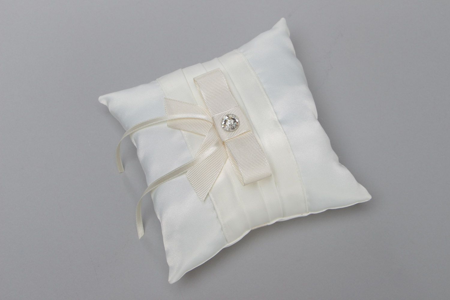 Tender handmade wedding ring pillow sewn of ivory-colored satin fabric with bow photo 2