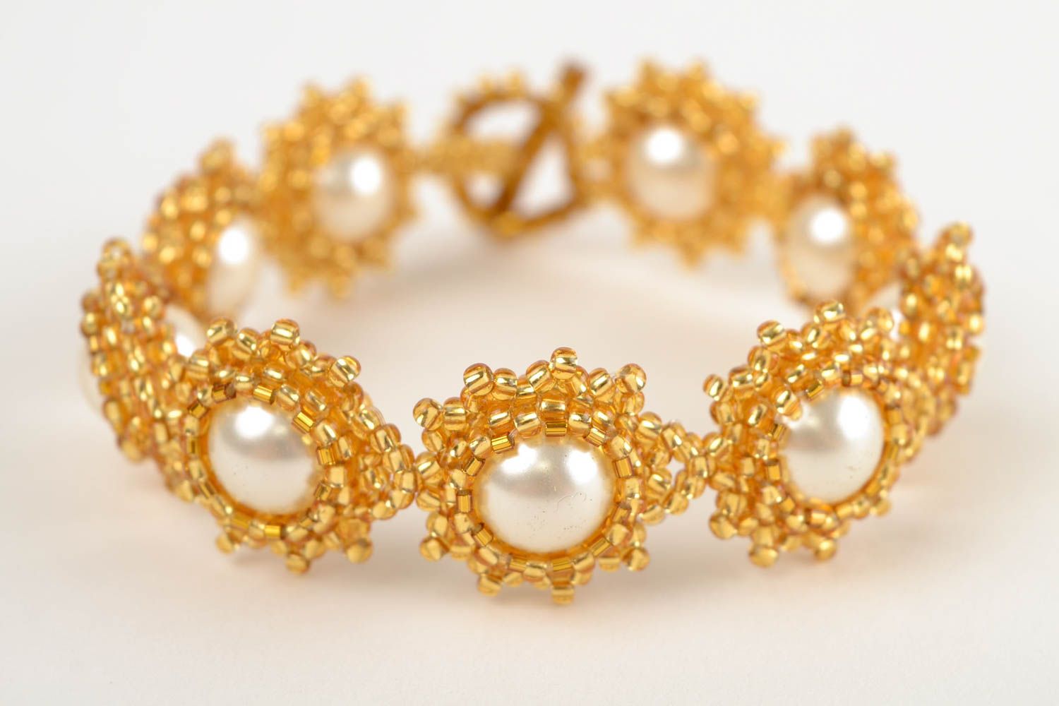 Beaded bracelet in the shape of flowers in gold and white colors photo 3