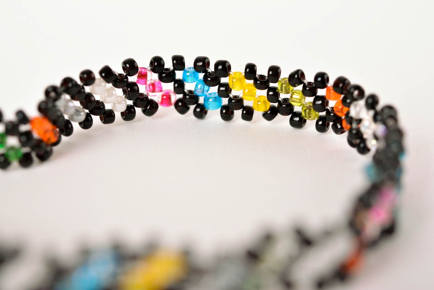 Thin handmade beaded bracelet made of black, green, red yellow beads for young girls photo 5