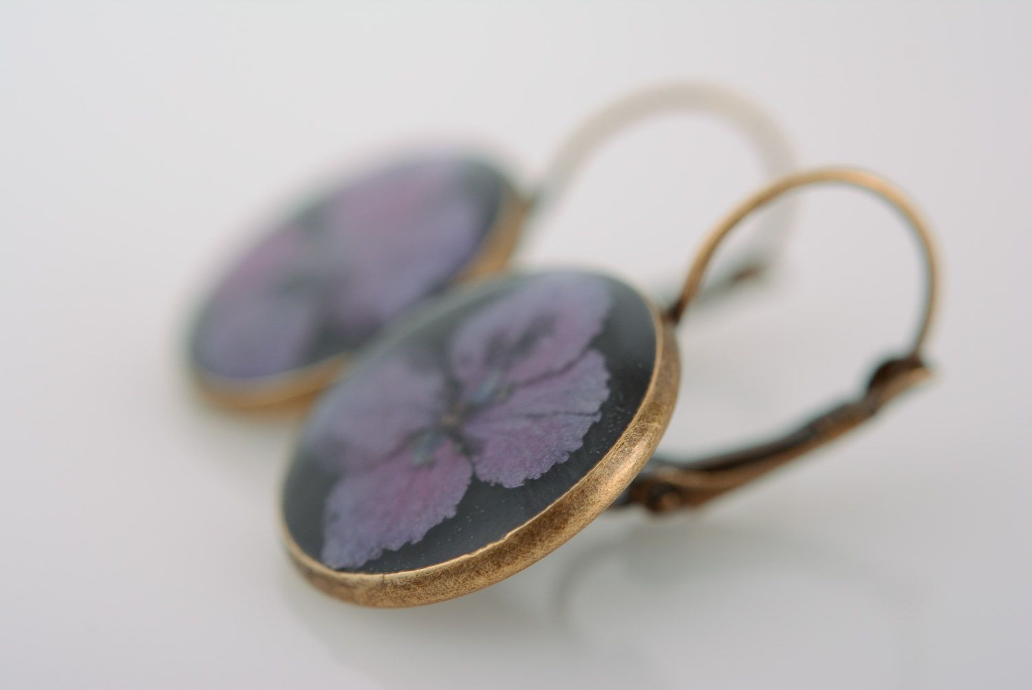 Homemade round black dangle earrings with violet flowers in epoxy resin photo 3