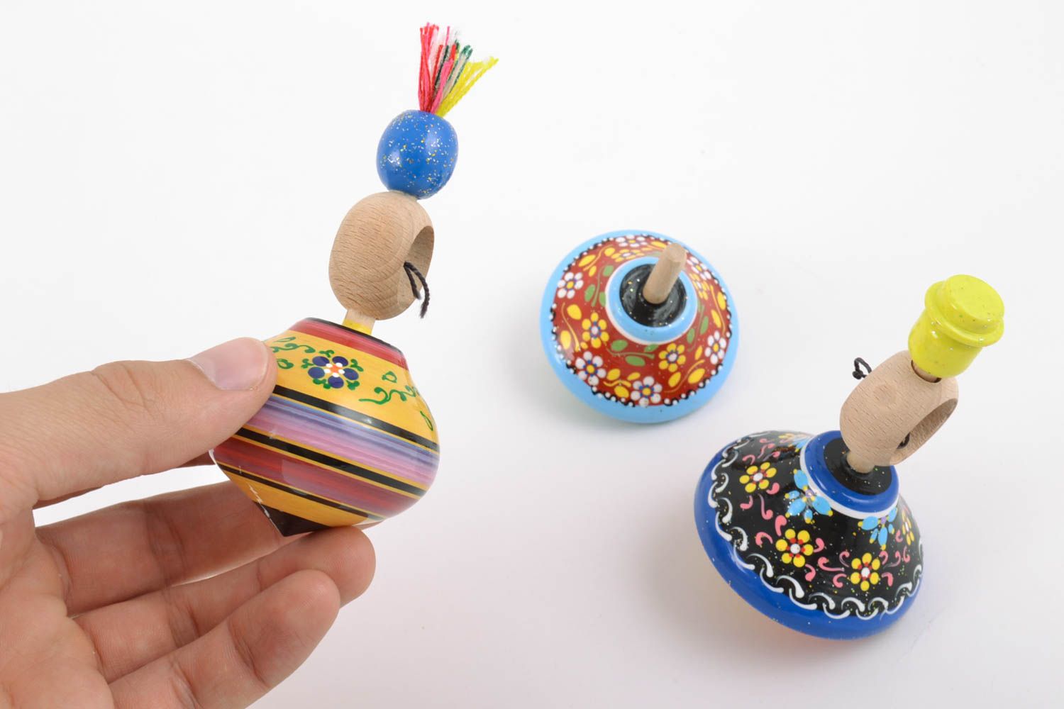 Conjunto de juguetes tres peonzas de madera artesanales pintadas a mano foto 4