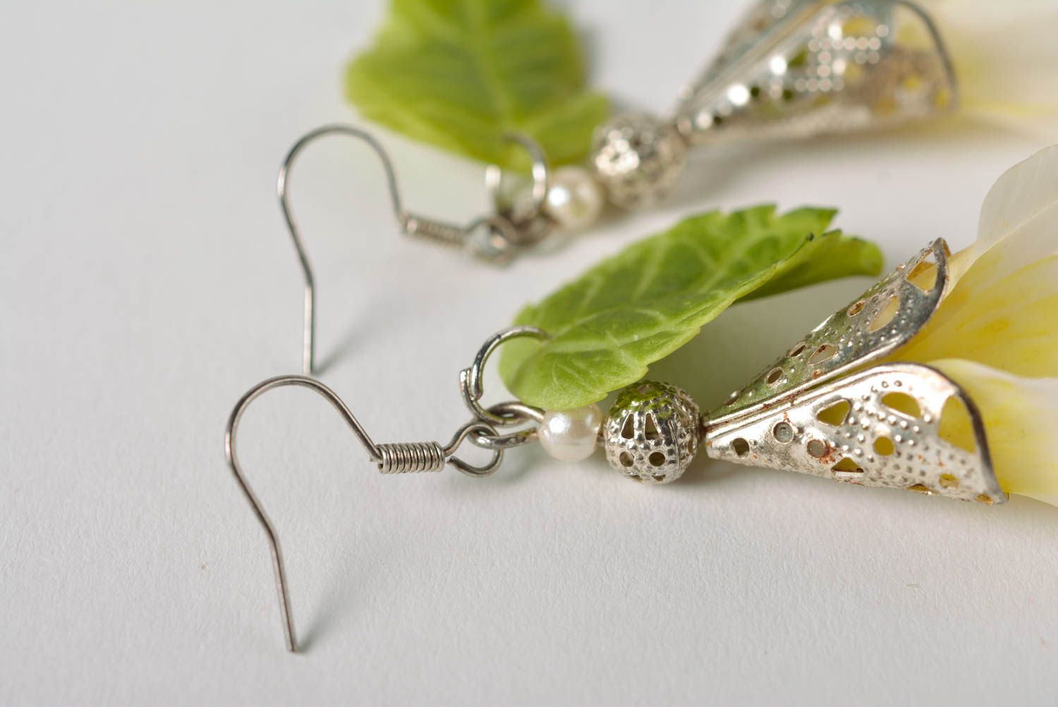 Handmade long earrings with white flowers and green leaves on metal basis photo 3
