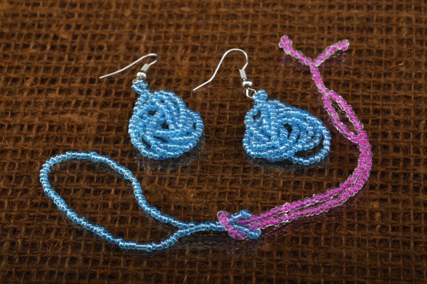 Set of handmade beaded jewelry long earrings and wrist bracelet on blue color photo 2