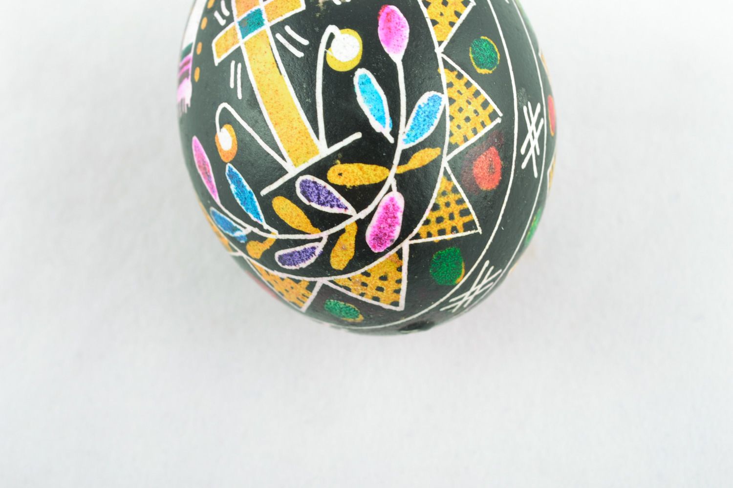 Beautiful chicken Easter egg pysanka with handmade painting on black background photo 5