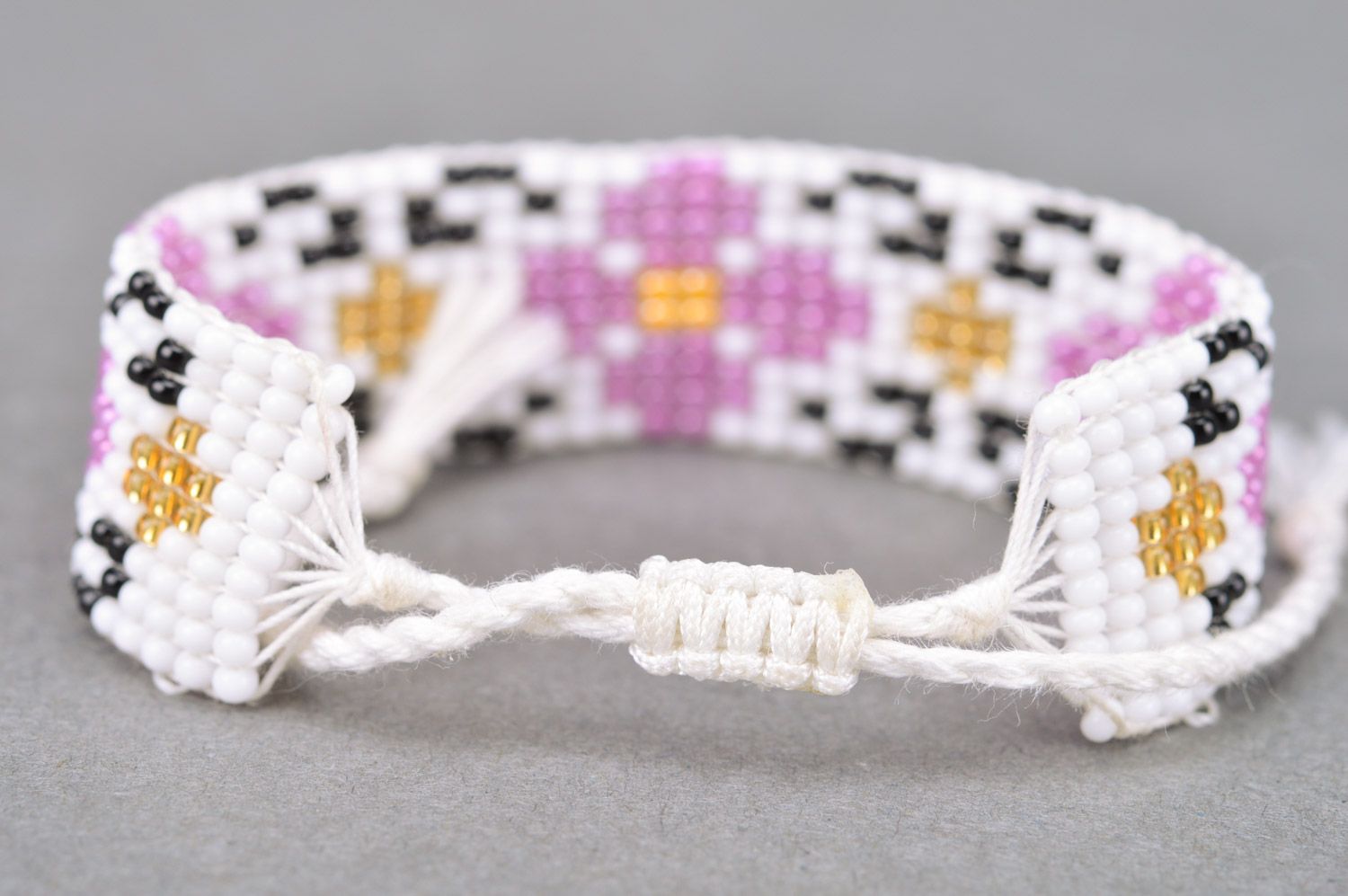 Handmade tender wrist bracelet woven of beads with floral ornament and ties photo 5