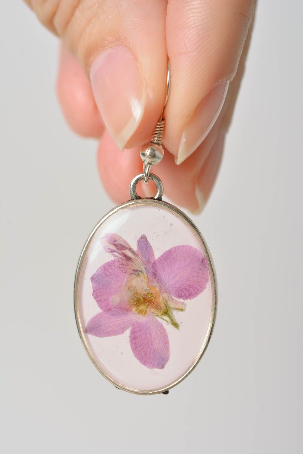 Handmade laconic oval dangle earrings with violet flowers in epoxy resin photo 2