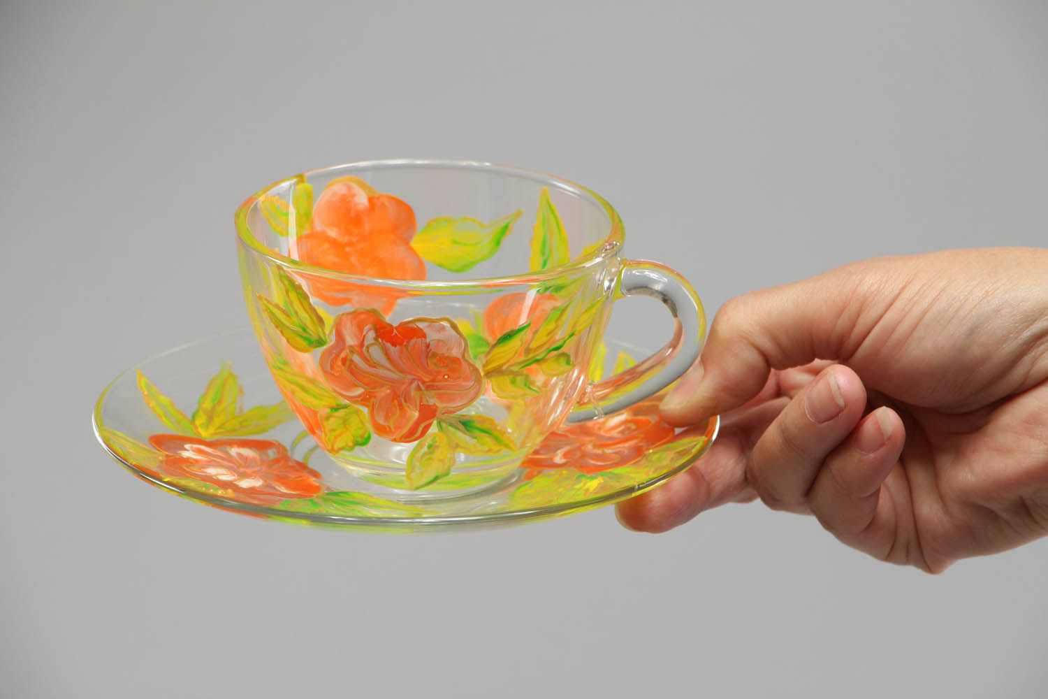 Clear glass tea cup with handle, saucer, and red and yellow flower pattern photo 4