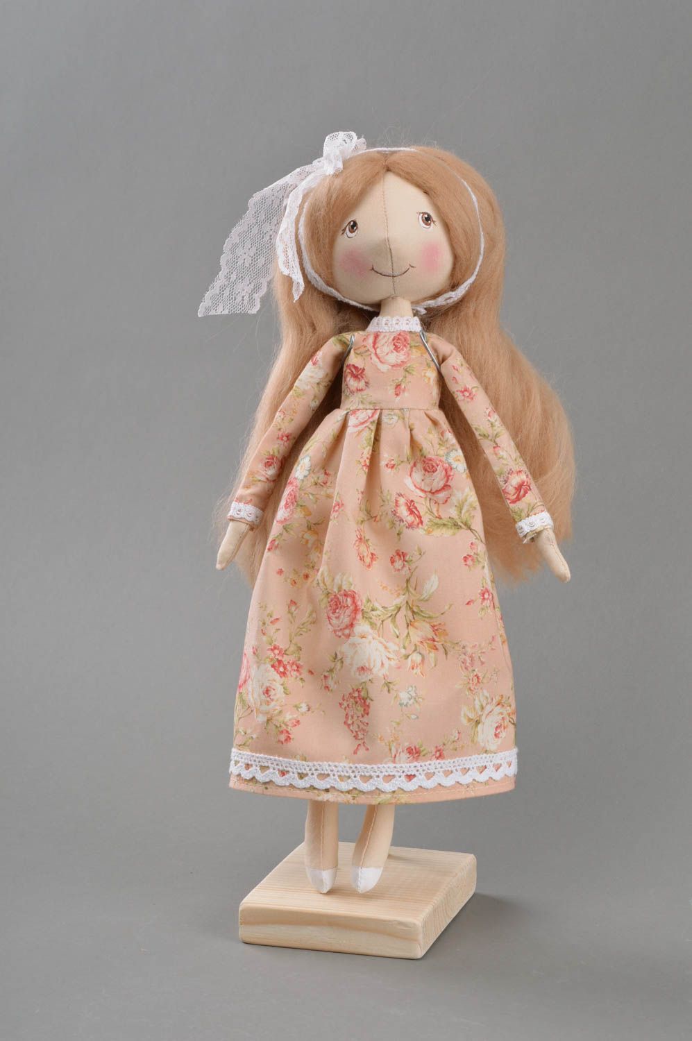 Handmade cute toy doll made of fabric in dress with flower print on stand photo 1