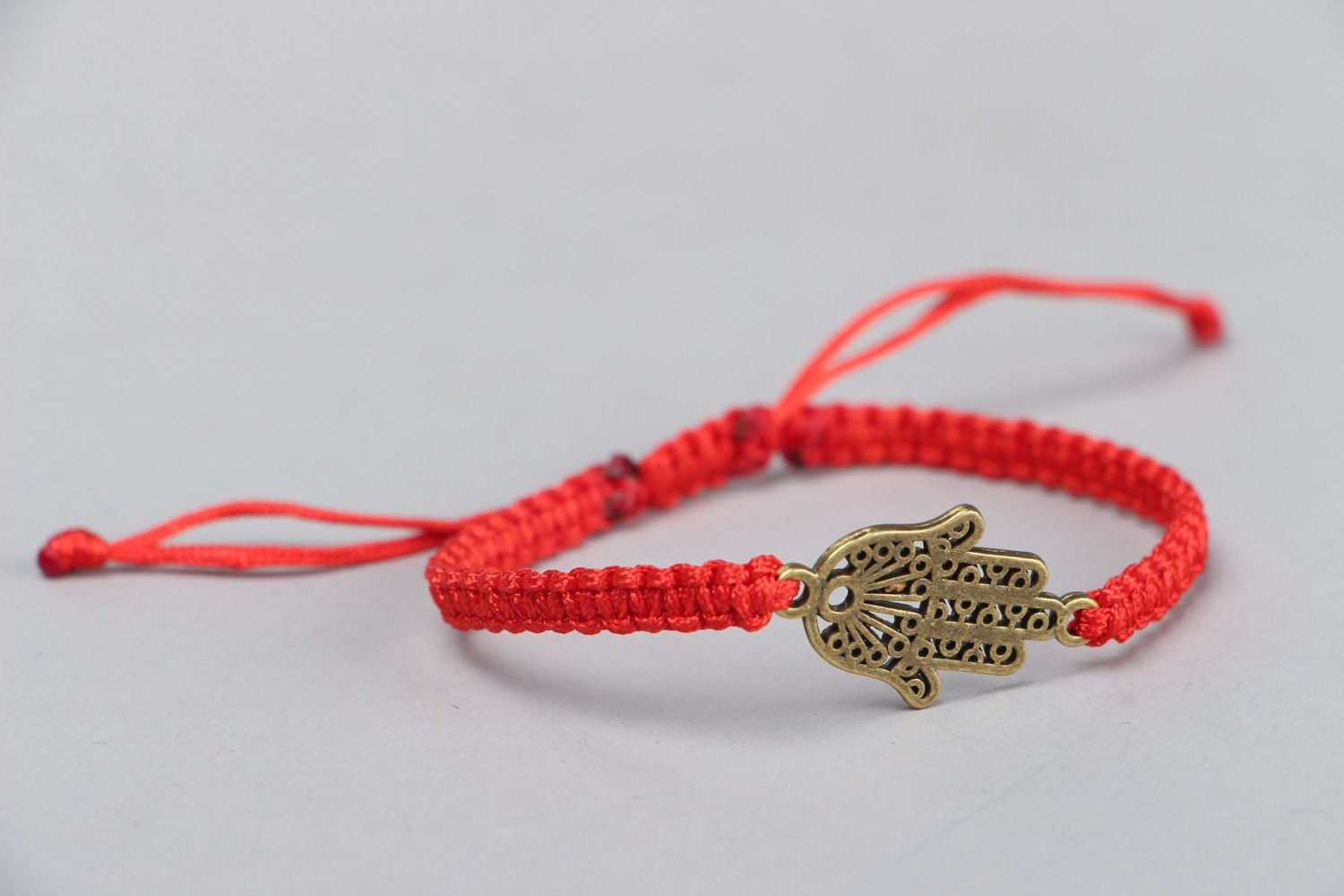 Thin handmade wrist friendship bracelet of red color with metal charm unisex photo 2