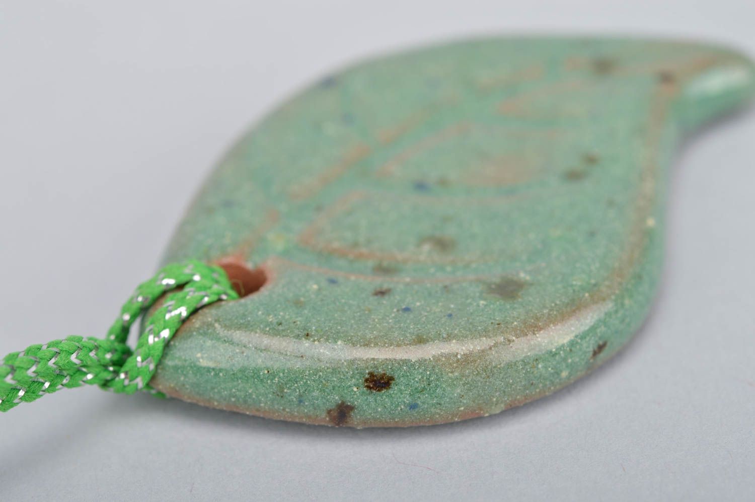 Handmade ceramic small pendant in the shape of light green leaf on a cord photo 4