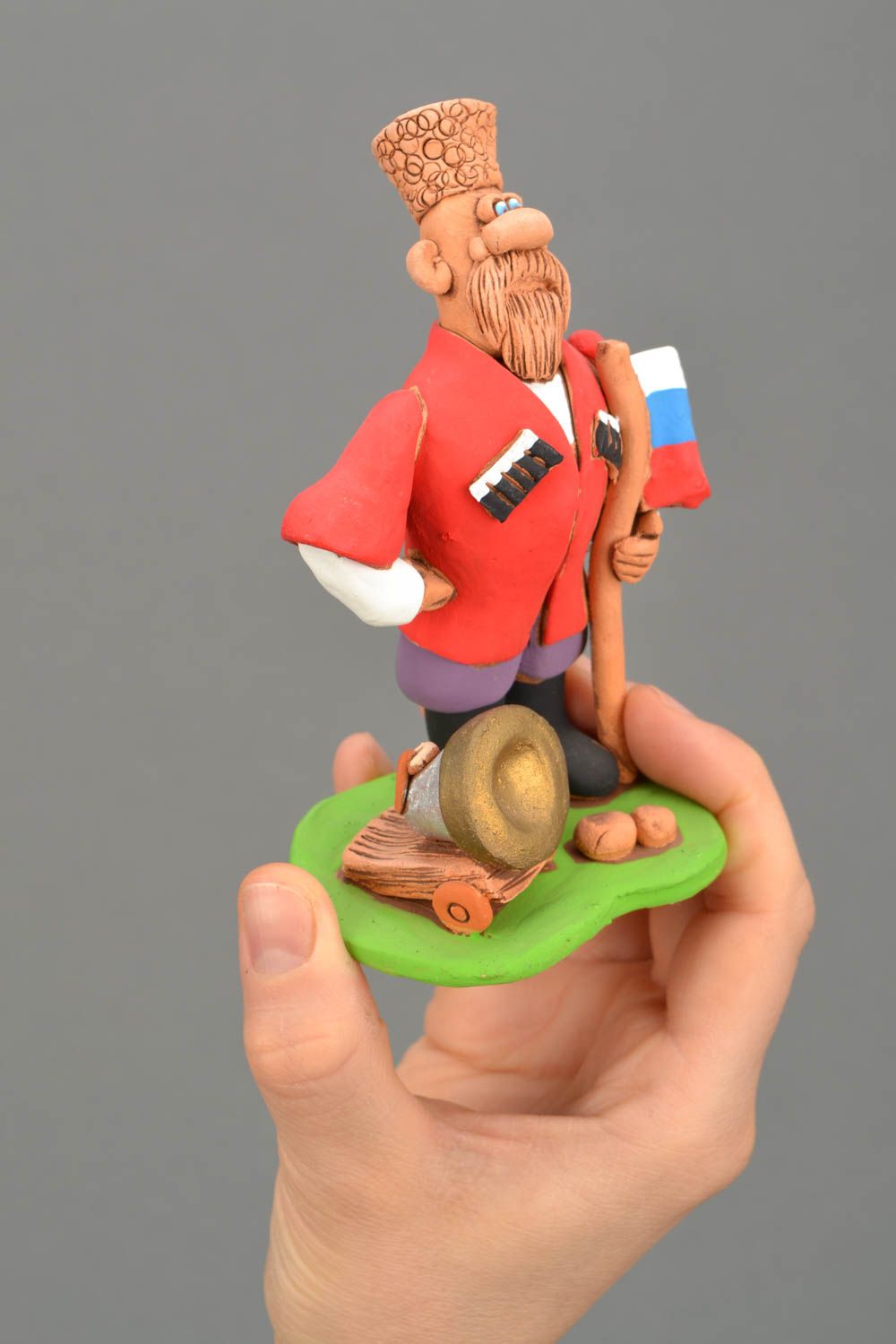 Handgemachte Figurine aus Ton Kosak mit der Kanone und Flagge foto 2