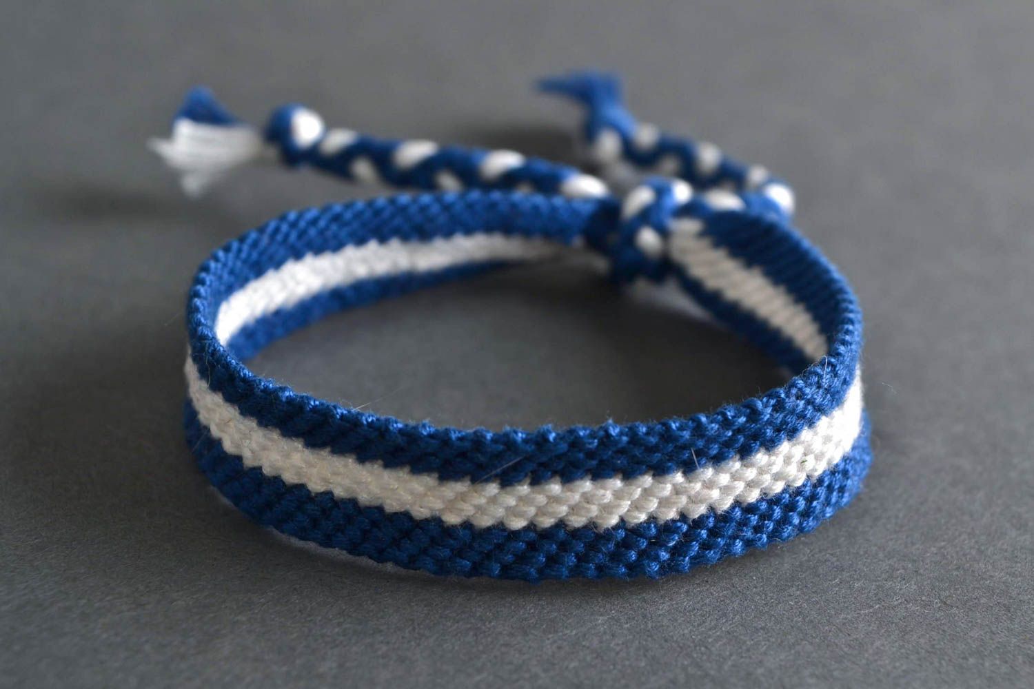 Handmade thin friendship wrist bracelet woven of blue and white threads photo 1