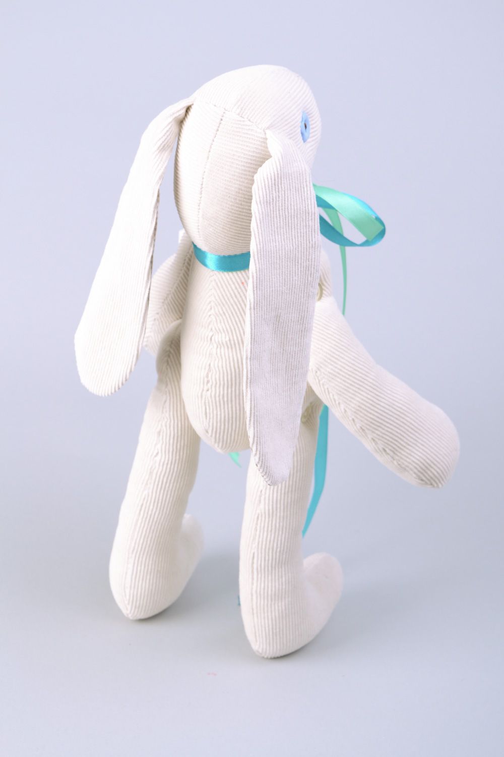 Handmade designer soft toy rabbit sewn of fabric of white color with blue bow photo 5