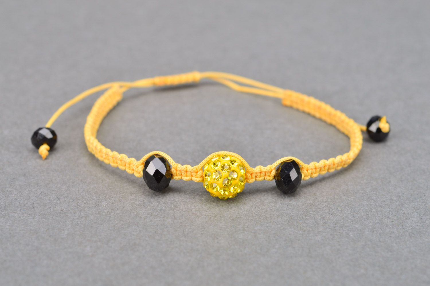 Stylish gentle handmade wrist bracelet woven of yellow threads and black beads photo 2