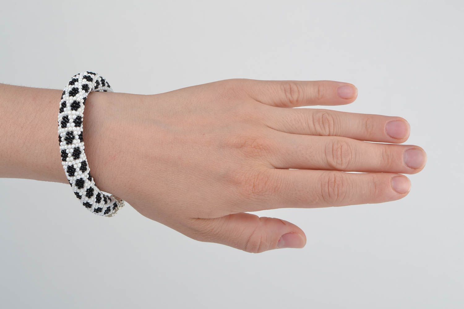 Handgemachtes gehäkeltes schwarz weißes Armband aus Glasperlen in Form von Litze foto 2