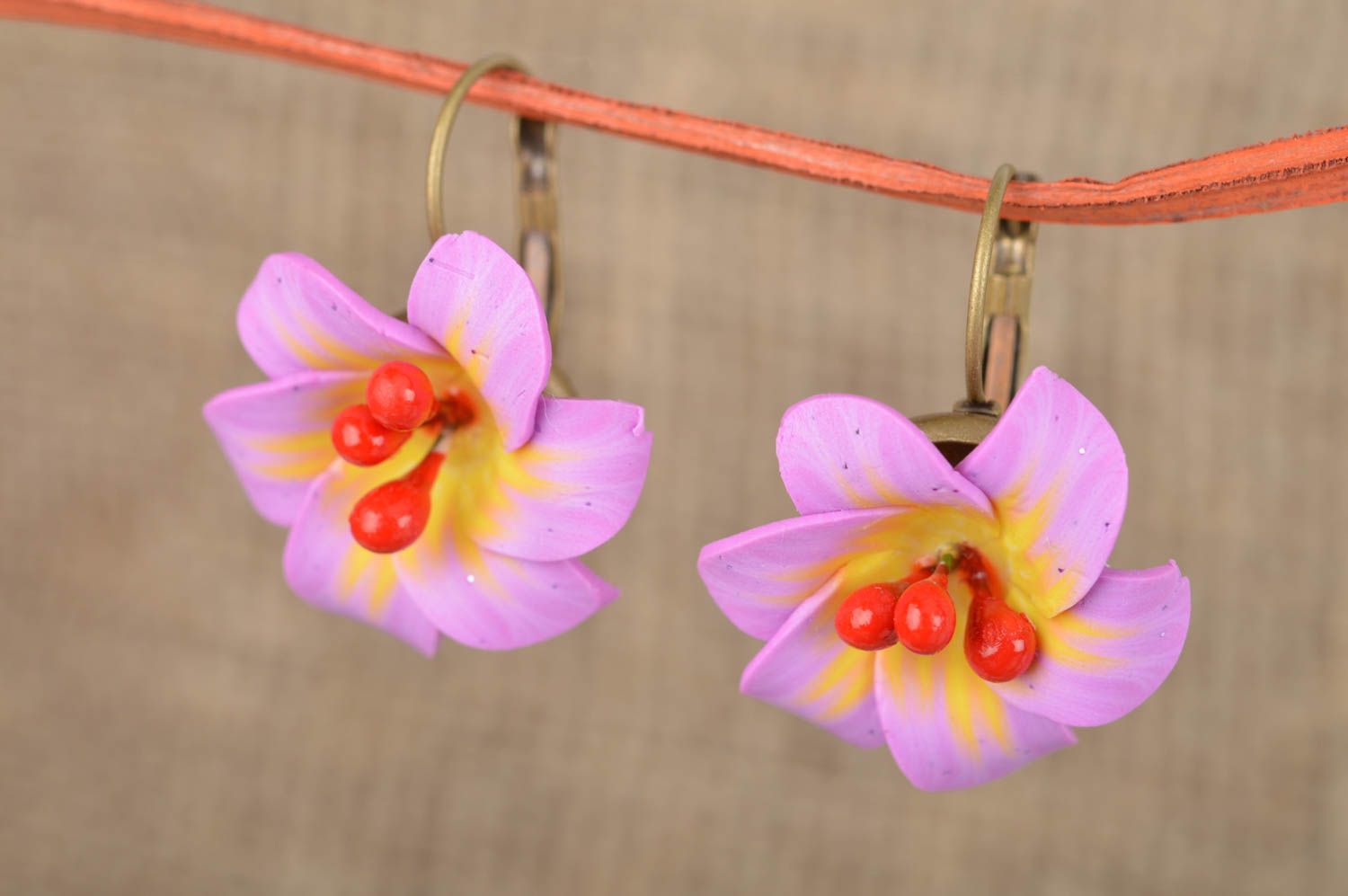 Feine violette originelle handgemachte Ohrringe aus Polymerton mit Blumen foto 1