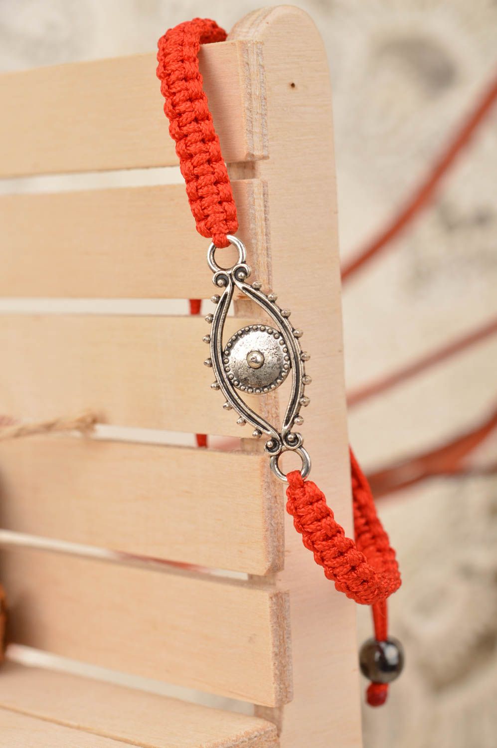 Handmade red bracelet made of silk threads with insert in shape of eye photo 1
