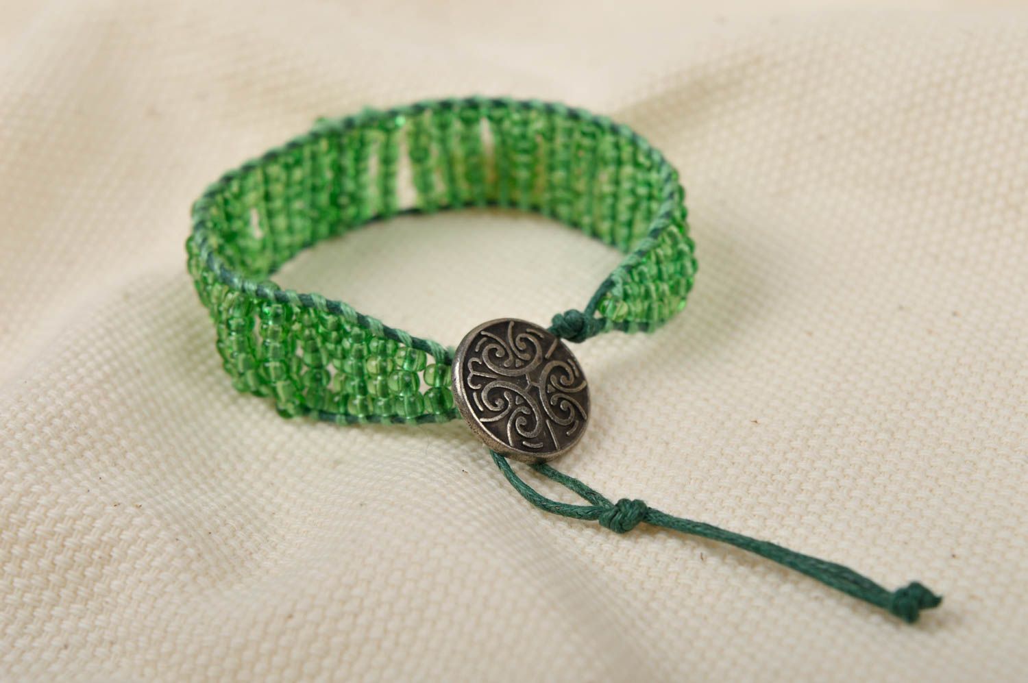 Light green homemade strand beaded bracelet with bronze token photo 1