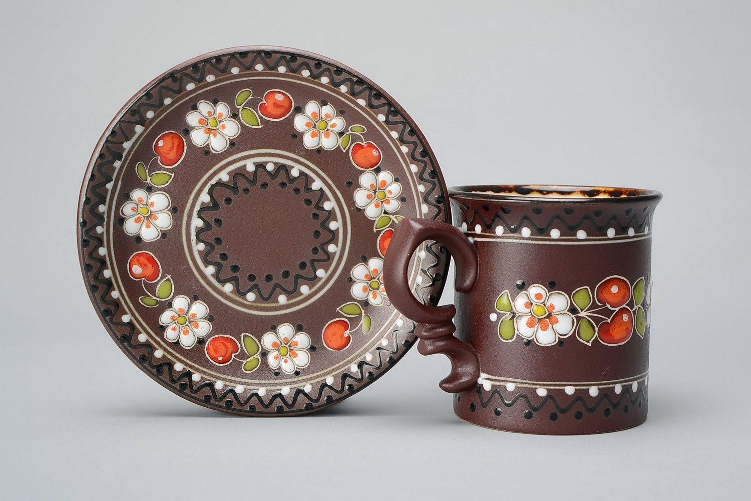 Ceramic glazed decorative brown te or coffee cup with handle, sauce and floral pattern photo 1