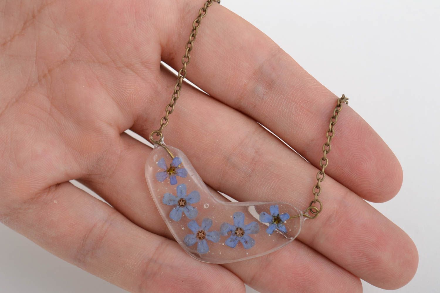 Tender handmade transparent epoxy resin pendant with blue flowers on metal chain photo 3